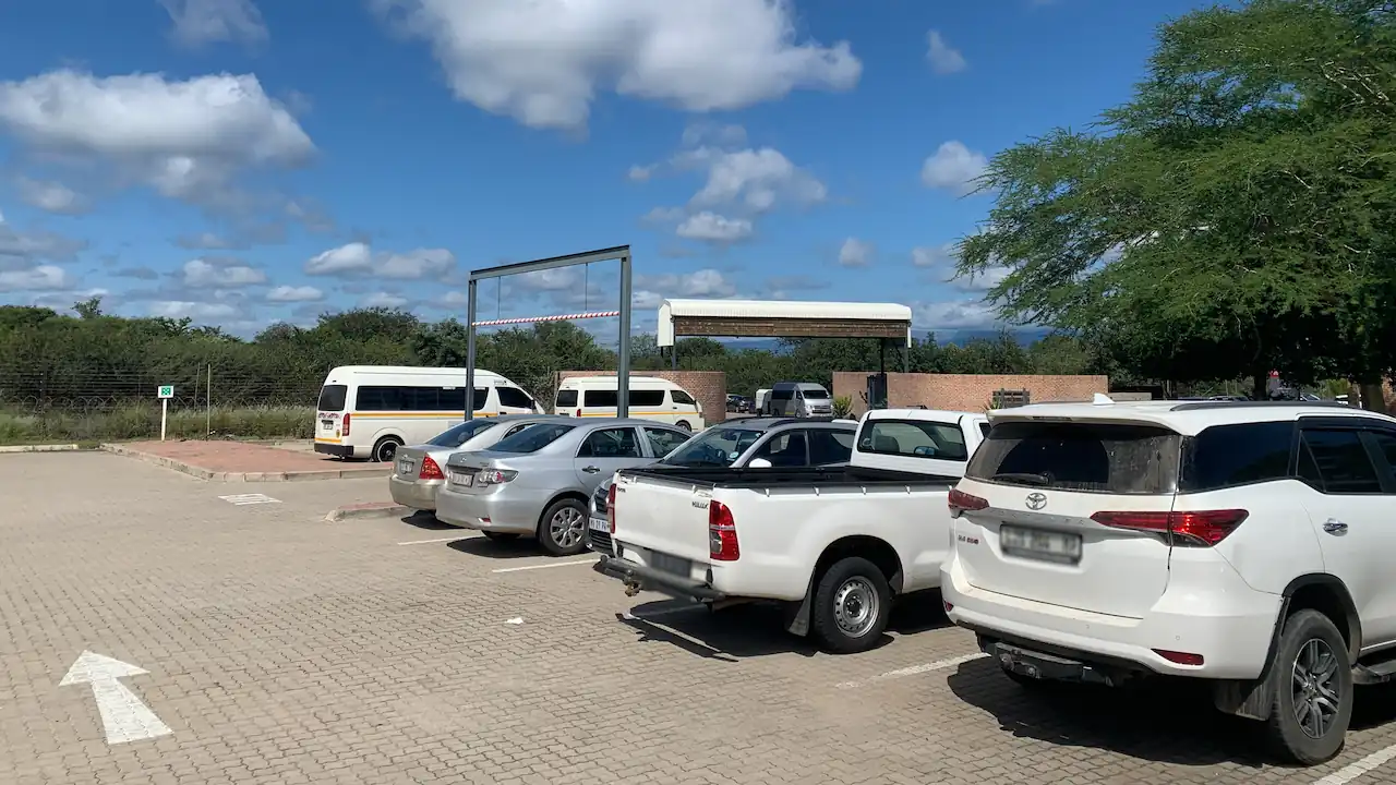 a vertical photo of vehicles parked in the East Gate Airport parking area.
